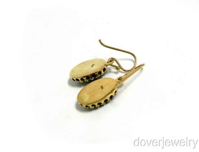  gold. These earrings are centered with 2 genuine oval cut Garnet